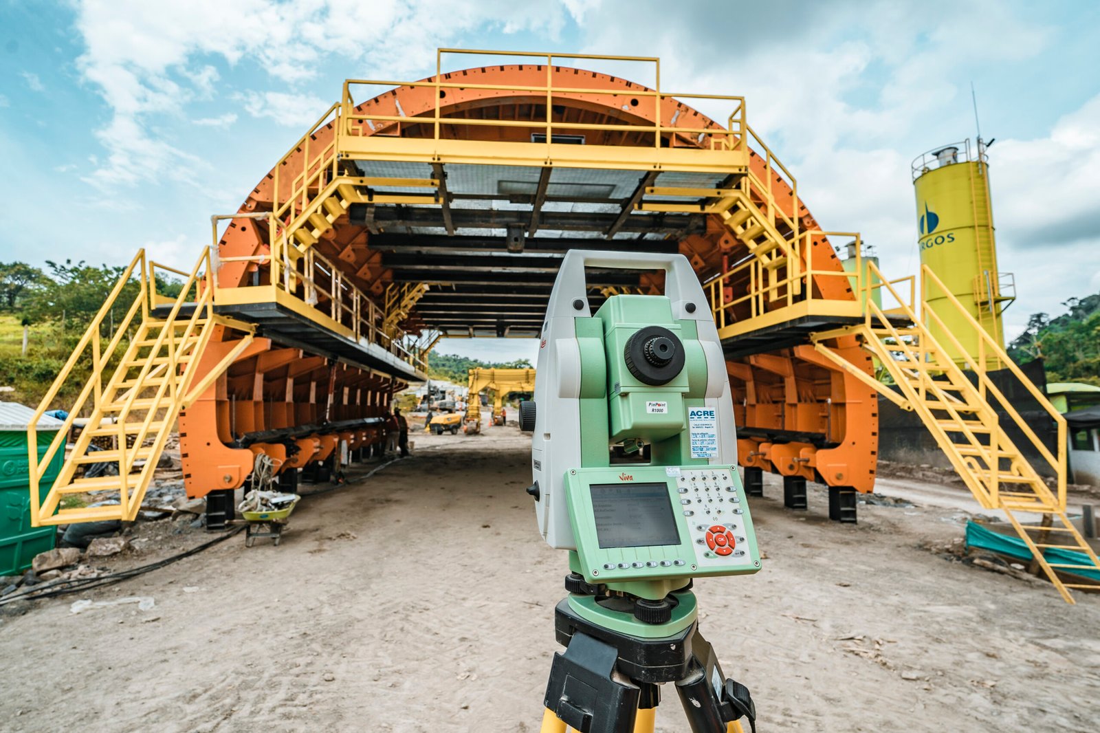Ingeniero con equipo topográfico en frente de obra